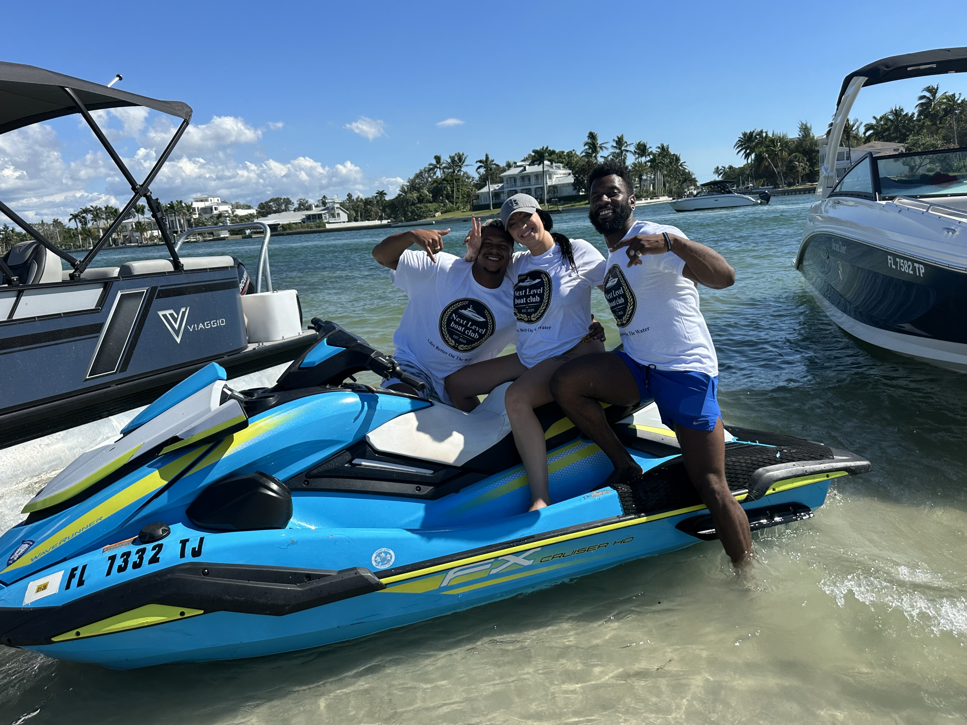 Three people on a jet ski, smiling
